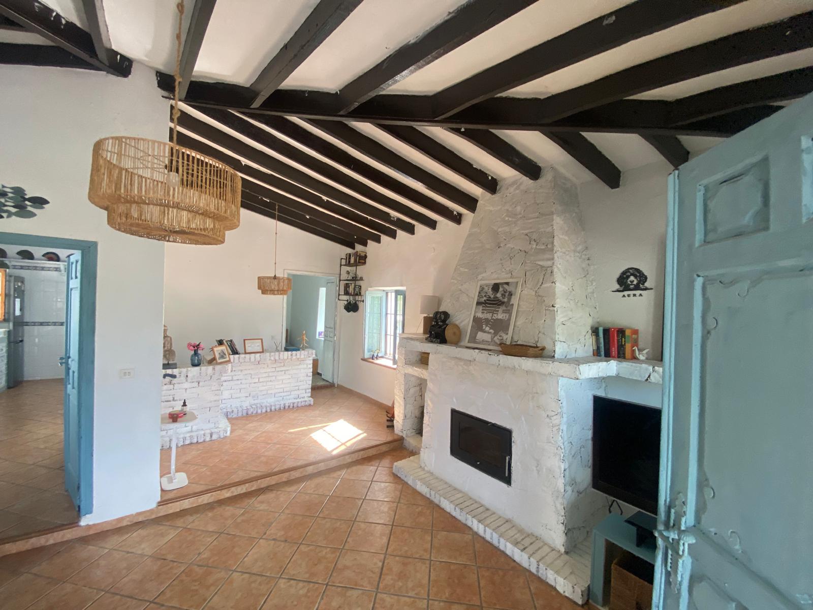 Bright living room with fireplace and wooden beams